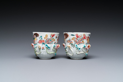 A pair of Chinese famille rose relief-decorated cups and saucers, Yongzheng