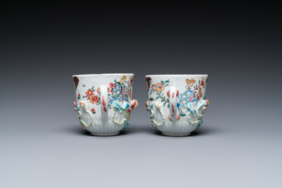 A pair of Chinese famille rose relief-decorated cups and saucers, Yongzheng