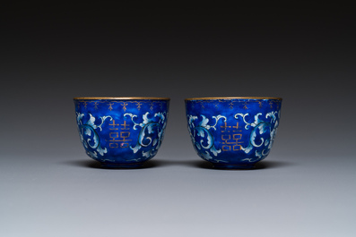 A pair of Chinese Canton enamel trembleuse cups on stands with double 'Shou' design, Qianlong