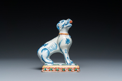 A polychrome Dutch Delft dog seated on a plinth, 18th C.