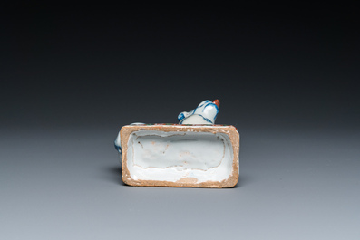 A polychrome Dutch Delft dog seated on a plinth, 18th C.