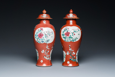 A pair of Chinese famille rose ruby-ground vases and covers, Yongzheng/Qianlong