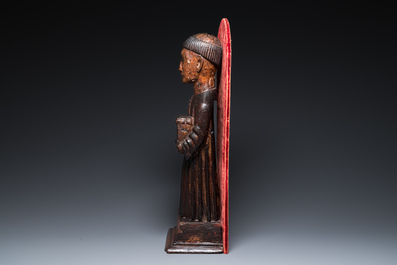 A partly gilded and polychromed wood sculpture of a monk holding a chest, probably Spain, 16th C.