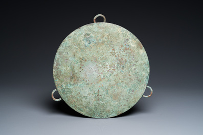 A large Chinese bronze mirror with turquoise and gold or gilt silver inlays, Warring States Period