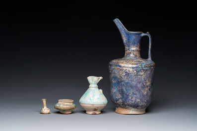 Three blue- and turquoise-glazed Islamic pottery wares and a glass bottle, Kashan and Raqqa, 12th C. and later