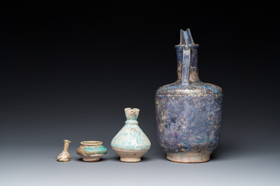 Three blue- and turquoise-glazed Islamic pottery wares and a glass bottle, Kashan and Raqqa, 12th C. and later