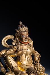 Een fijne Sino-Tibetaanse vergulde bronzen sculptuur van Jambhala, 18e eeuw