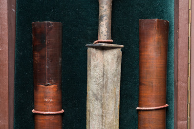 A Chinese bronze dagger with wooden scabbard in a display case, Han