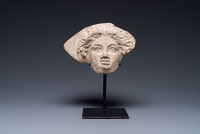 A Greek terracotta with white engobe antefix in the shape of a woman's head, 5/4th C. b.C.