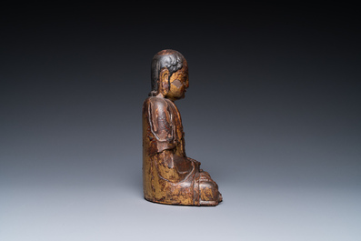 Een Chinese gelakte en vergulde houten sculptuur van een Arhat, Ming