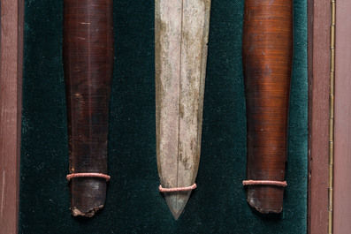 A Chinese bronze dagger with wooden scabbard in a display case, Han