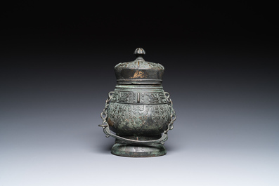 Een Chinese archa&iuml;sche rituele bronzen 'you' wijnkan met deksel in Westelijke Zhou-stijl, Ming