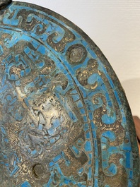 A large Chinese bronze mirror with turquoise and gold or gilt silver inlays, Warring States Period