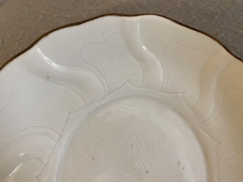 Assiette moul&eacute;e en forme de lotus en porcelaine de Chine en blanc monochrome &agrave; d&eacute;cor incis&eacute;, marque de Xuande, &eacute;poque Transition