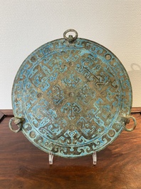 A large Chinese bronze mirror with turquoise and gold or gilt silver inlays, Warring States Period