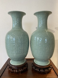 Een paar Chinese monochrome celadon vazen met onderglazuur decor op houten sokkels, Qianlong merk, 18/19e eeuw