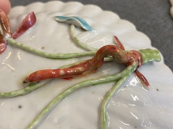 A pair of Chinese famille rose relief-decorated cups and saucers, Yongzheng