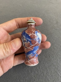 A Chinese blue, white and copper-red 'dogs' snuff bottle, 19th C.