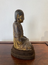Een Chinese gelakte en vergulde houten sculptuur van een Arhat, Ming