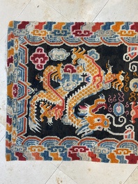 A Tibetan rug with two dragons chasing the pearl of wisdom, 19th C.