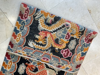 A Tibetan rug with two dragons chasing the pearl of wisdom, 19th C.