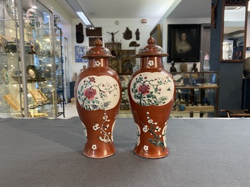 A pair of Chinese famille rose ruby-ground vases and covers, Yongzheng/Qianlong