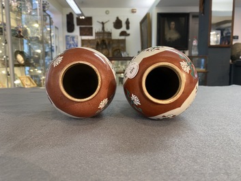 A pair of Chinese famille rose ruby-ground vases and covers, Yongzheng/Qianlong