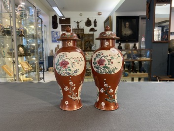 A pair of Chinese famille rose ruby-ground vases and covers, Yongzheng/Qianlong