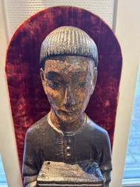 A partly gilded and polychromed wood sculpture of a monk holding a chest, probably Spain, 16th C.