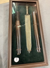 A Chinese bronze dagger with wooden scabbard in a display case, Han