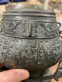 Een Chinese archa&iuml;sche rituele bronzen 'you' wijnkan met deksel in Westelijke Zhou-stijl, Ming