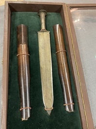 A Chinese bronze dagger with wooden scabbard in a display case, Han