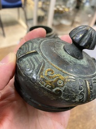 Een Chinese archa&iuml;sche rituele bronzen 'you' wijnkan met deksel in Westelijke Zhou-stijl, Ming