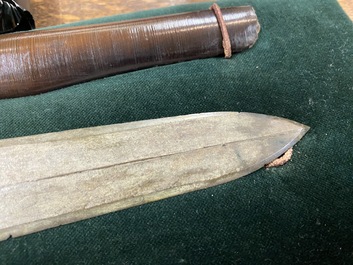 A Chinese bronze dagger with wooden scabbard in a display case, Han