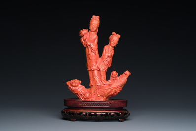 A Chinese red coral group of two standing ladies with lotus flowers, 19/20th C.