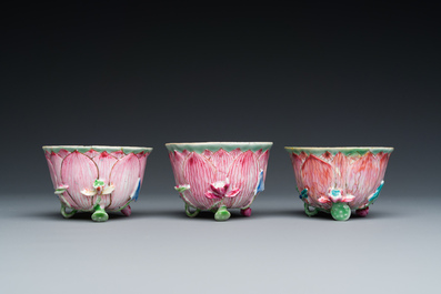 Three Chinese relief-decorated famille rose 'lotus' cups and saucers with a scholar and his servant, Yongzheng