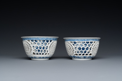 A pair of Chinese blue and white reticulated double-walled cups and saucers, Kangxi