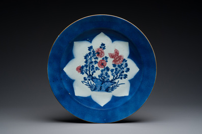 Three large Chinese blue, white and copper-red powder-blue-ground dishes with floral design, Kangxi