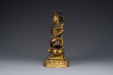 A Sino-Tibetan gilt bronze sculpture of Vaishravana on a Buddhist lion, probably 17th C.