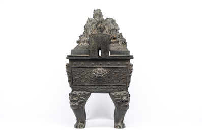 A large Chinese bronze censer and cover with a dragon in a rocky landscape with various animals, Yuan