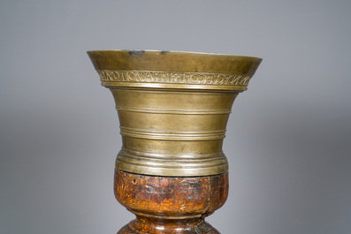 A large French bronze mortar and pestle on its carved oak base, dated 1631