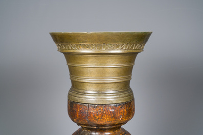 A large French bronze mortar and pestle on its carved oak base, dated 1631
