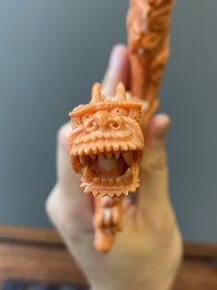A Chinese red coral figure of a standing Bodhisattva with two dragons, 19/20th C.