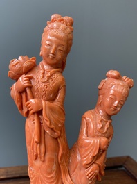 A Chinese red coral group of two standing ladies with lotus flowers, 19/20th C.