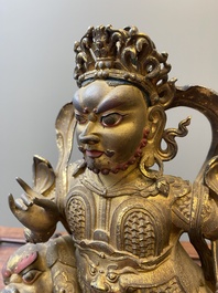 A Sino-Tibetan gilt bronze sculpture of Vaishravana on a Buddhist lion, probably 17th C.