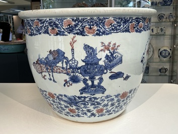 An exceptional massive Chinese blue, white and copper-red fish bowl with antiquities and 'Master of the rocks'-style panels, Kangxi