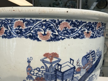 An exceptional massive Chinese blue, white and copper-red fish bowl with antiquities and 'Master of the rocks'-style panels, Kangxi