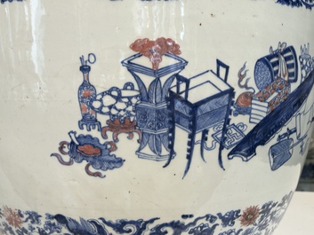 An exceptional massive Chinese blue, white and copper-red fish bowl with antiquities and 'Master of the rocks'-style panels, Kangxi