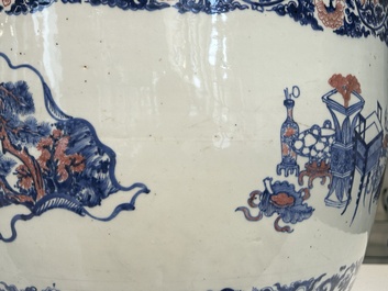 An exceptional massive Chinese blue, white and copper-red fish bowl with antiquities and 'Master of the rocks'-style panels, Kangxi