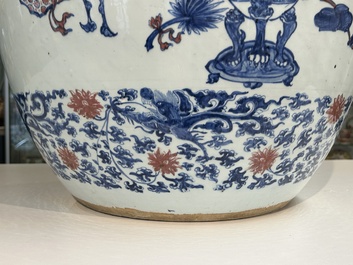 An exceptional massive Chinese blue, white and copper-red fish bowl with antiquities and 'Master of the rocks'-style panels, Kangxi